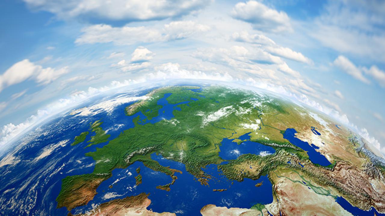 Vista da Terra vista do espaço mostrando a Europa, partes da Ásia e África sob um céu claro com nuvens.